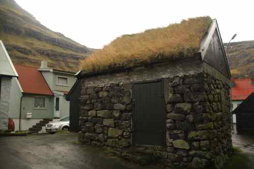 A turf-roofed house in a small Faroese town