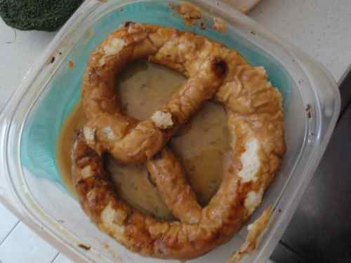 a pretzel jammed into its soaking tupperware